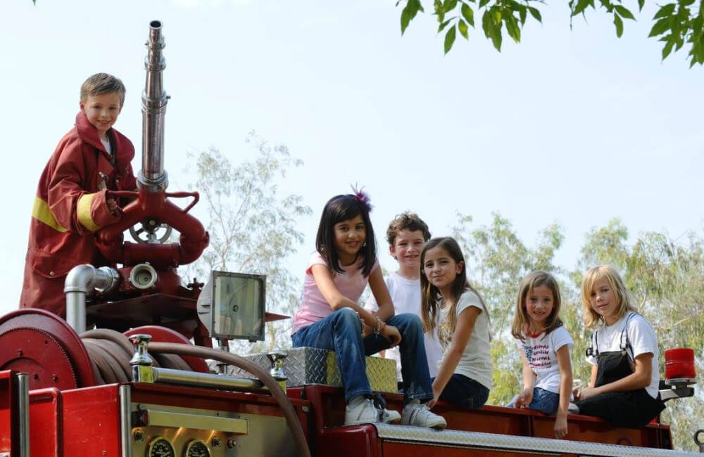 Children sitting on fire truck.